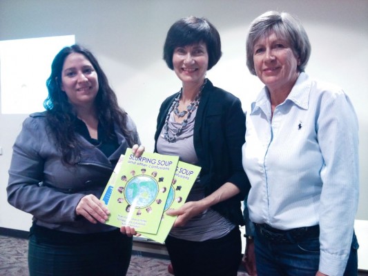 Gladstone Women's Intercultural Network coordinator Natalia Muszcat checks out 'Slurping Soup' with Kathryn Tonges and her sister Julie Charles a WIN volunteer.